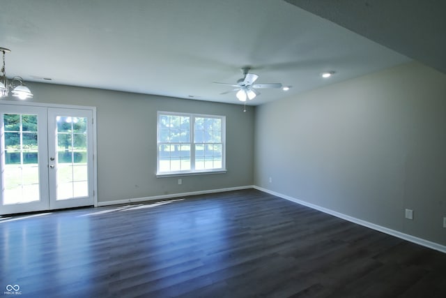 spare room with ceiling fan with notable chandelier, french doors, and dark hardwood / wood-style flooring