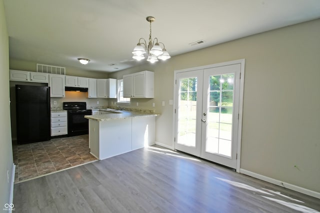 kitchen featuring dark hardwood / wood-style flooring, decorative light fixtures, kitchen peninsula, white cabinets, and black appliances