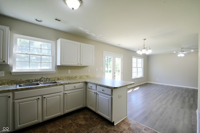 kitchen featuring white cabinets, plenty of natural light, sink, and kitchen peninsula