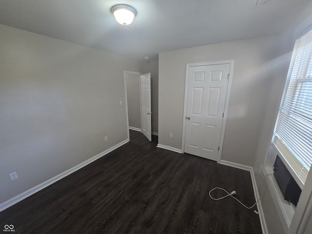 unfurnished bedroom with dark hardwood / wood-style floors