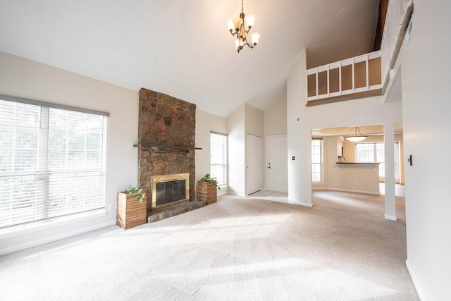 unfurnished living room with carpet floors, a fireplace, high vaulted ceiling, and an inviting chandelier