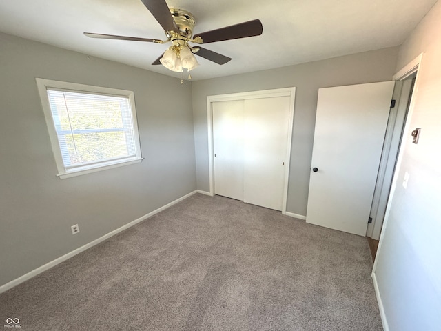 unfurnished bedroom with a closet, ceiling fan, and light carpet