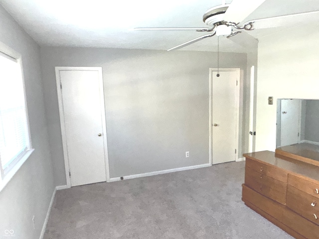 interior space with ceiling fan, carpet flooring, and multiple windows