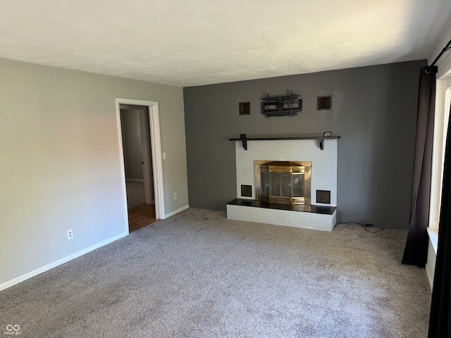 unfurnished living room with carpet and a brick fireplace