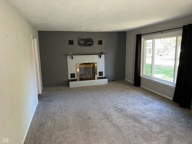 unfurnished living room featuring a brick fireplace and light colored carpet