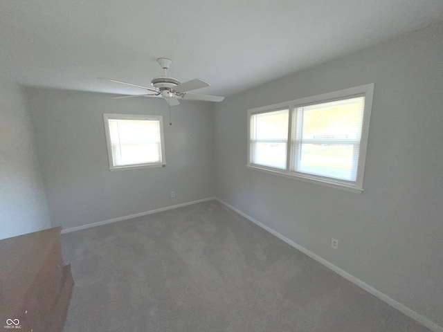 carpeted spare room featuring ceiling fan