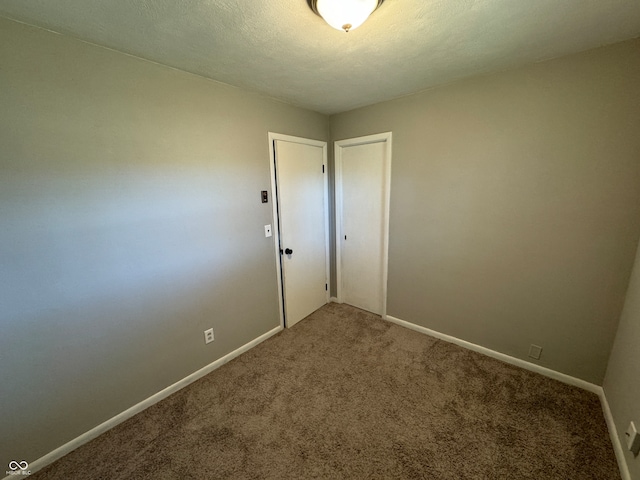 carpeted empty room with a textured ceiling