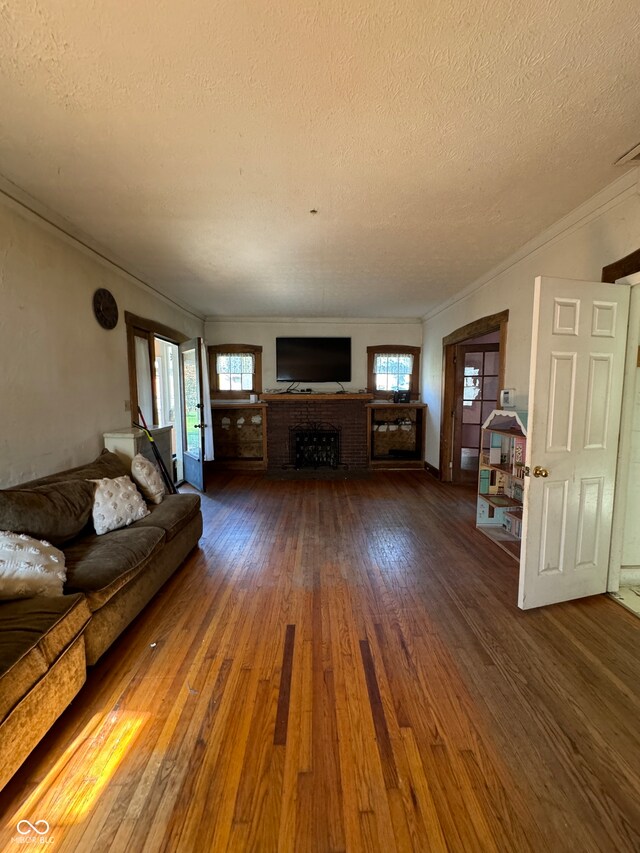 unfurnished living room featuring a textured ceiling, crown molding, and dark hardwood / wood-style flooring