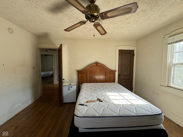 unfurnished bedroom featuring a textured ceiling, ceiling fan, and dark hardwood / wood-style flooring