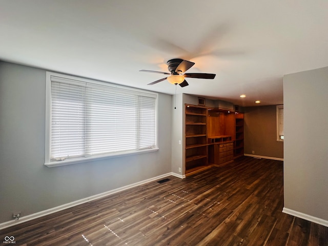 unfurnished room featuring ceiling fan and dark wood-type flooring