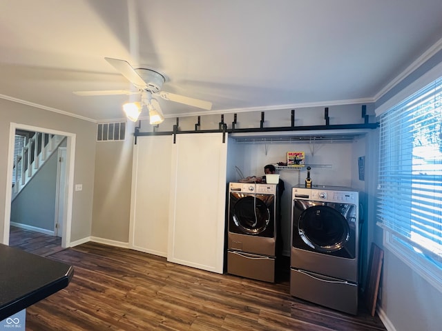 washroom featuring a barn door, ornamental molding, dark hardwood / wood-style floors, and washing machine and clothes dryer