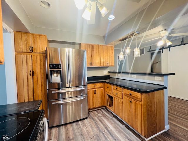 kitchen featuring ceiling fan, decorative light fixtures, stainless steel fridge, and hardwood / wood-style floors