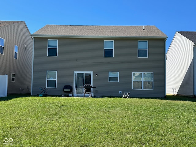 rear view of property featuring a lawn and a patio area