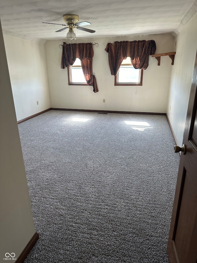 unfurnished room featuring carpet, ceiling fan, and a wealth of natural light