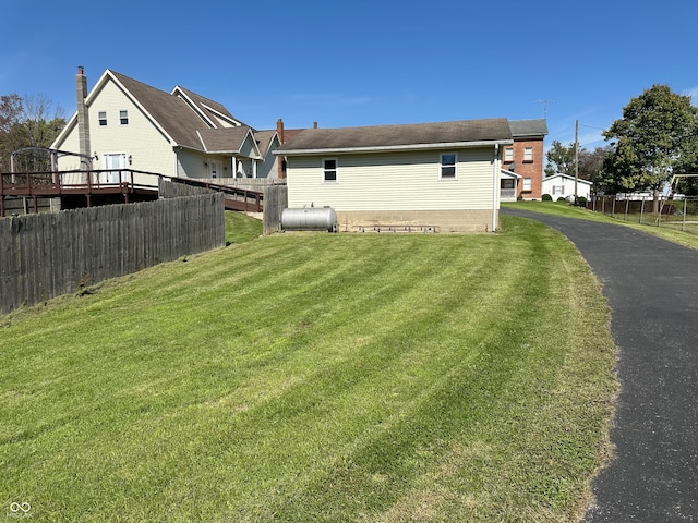 rear view of property with a lawn and a wooden deck