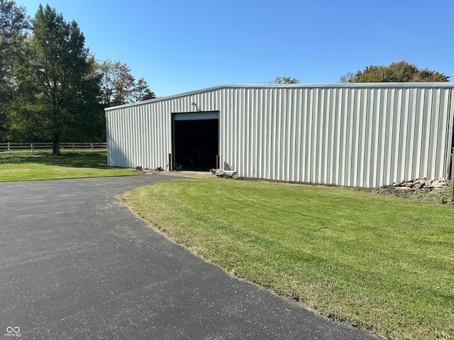 view of outdoor structure featuring a garage and a lawn