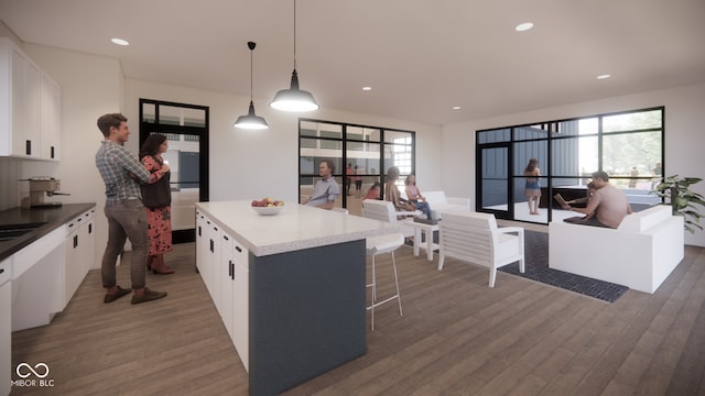 kitchen with decorative light fixtures, a center island, dark wood-type flooring, and white cabinetry