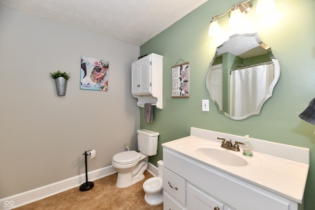 bathroom featuring vanity, a textured ceiling, and toilet