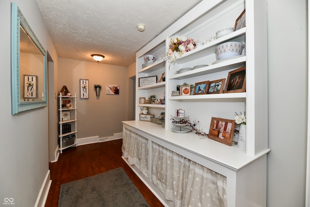 hallway featuring dark hardwood / wood-style floors and a textured ceiling