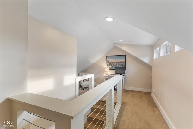 hallway with lofted ceiling and light carpet