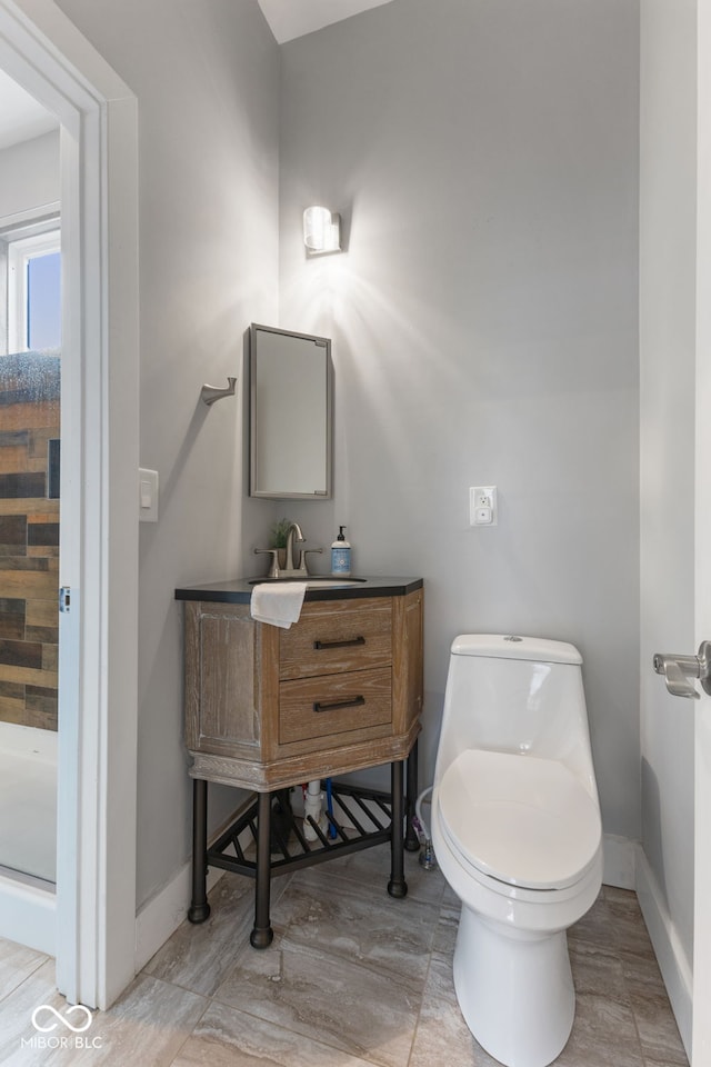 bathroom with walk in shower, vanity, and toilet