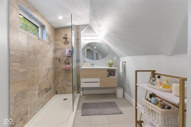 bathroom featuring vanity, lofted ceiling, a shower with shower door, and tile patterned floors