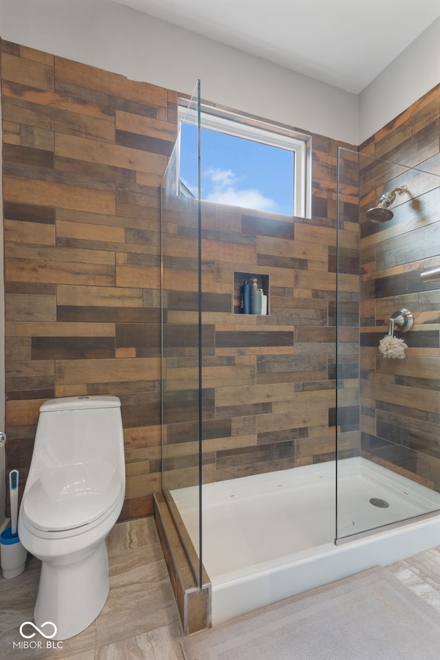 bathroom featuring wooden walls, a shower with door, and toilet