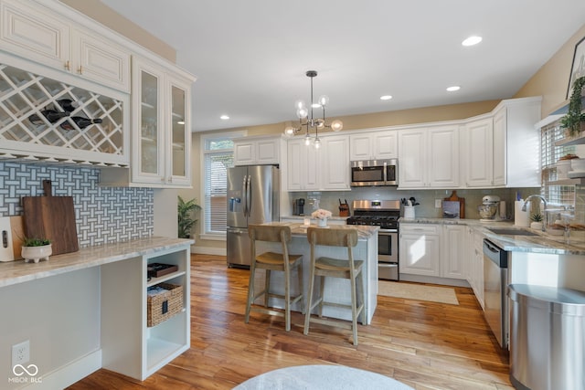 kitchen with light hardwood / wood-style flooring, white cabinets, and appliances with stainless steel finishes