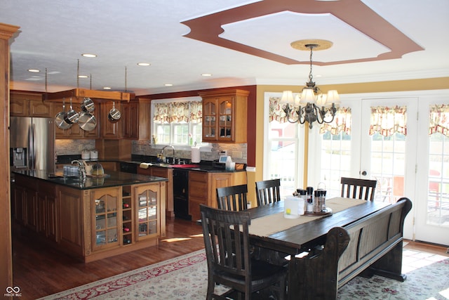 dining area with a wealth of natural light, sink, hardwood / wood-style flooring, and crown molding