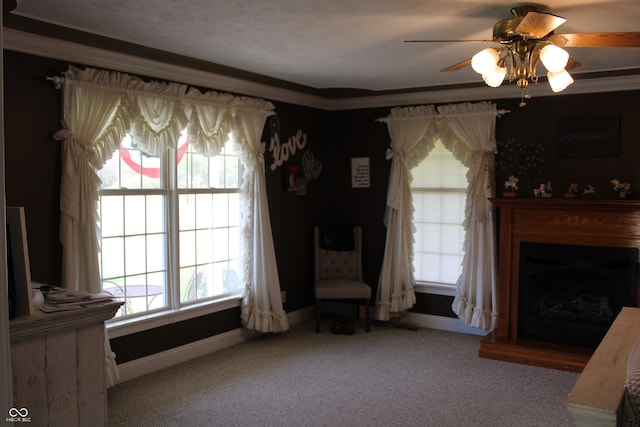 carpeted living room with ornamental molding and ceiling fan