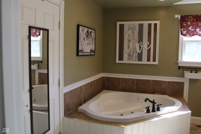 bathroom with tiled bath and plenty of natural light