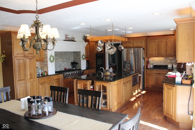 kitchen with light wood-type flooring, a kitchen island, an inviting chandelier, backsplash, and appliances with stainless steel finishes