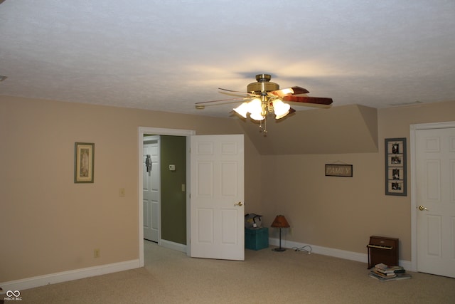 bonus room with light carpet, ceiling fan, and a textured ceiling