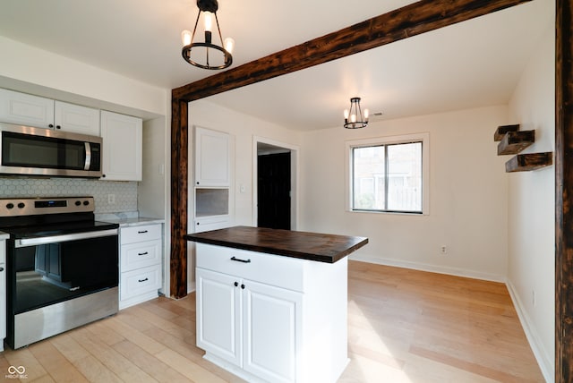 kitchen with white cabinets, a chandelier, butcher block counters, decorative light fixtures, and stainless steel appliances