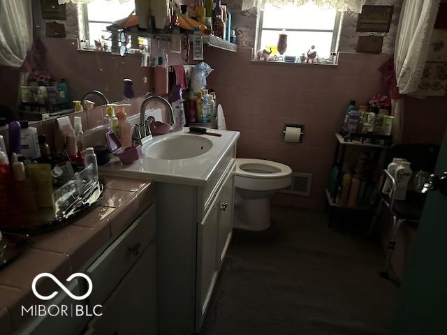 4434 E 46th St, Indianapolis, IN 46226 - bathroom with visible vents, a wealth of natural light, vanity, and toilet