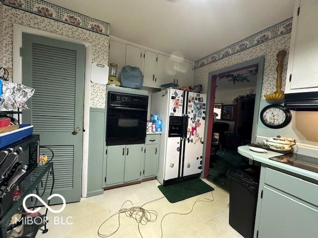 4434 E 46th St, Indianapolis, IN 46226 - kitchen featuring wallpapered walls, white refrigerator with ice dispenser, light tile patterned flooring, light countertops, and black oven
