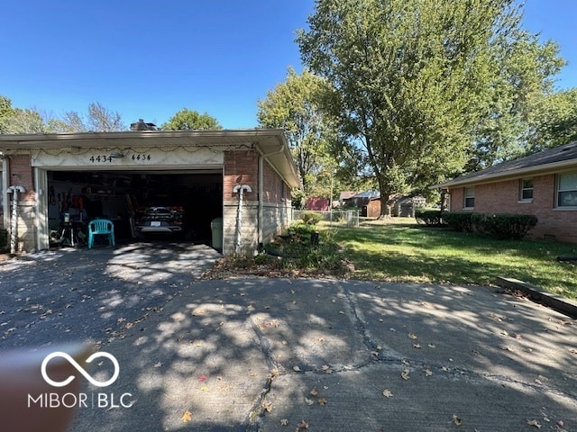 exterior space featuring a garage and a lawn