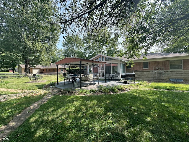 rear view of house featuring a yard and a patio