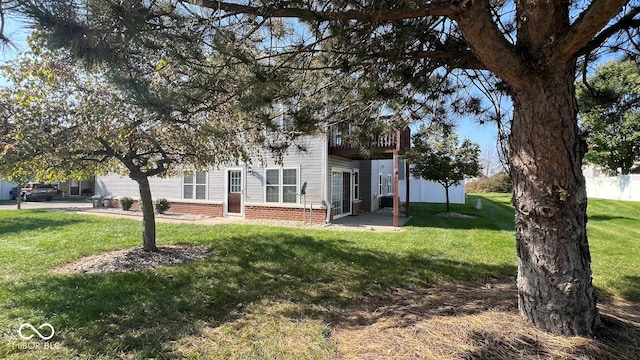 exterior space with a patio area, brick siding, and a front yard