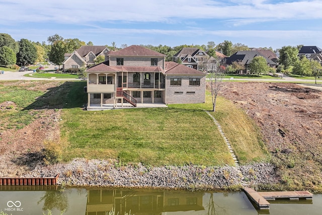 rear view of property with a yard, a patio, and a water view