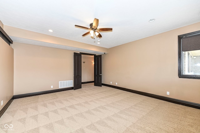 spare room featuring ceiling fan and light colored carpet