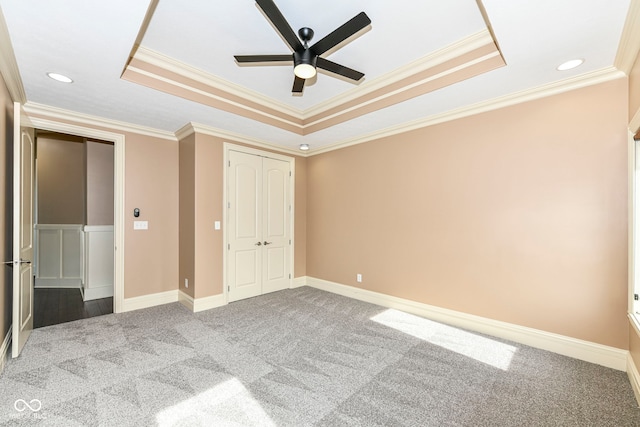 unfurnished bedroom with crown molding, a tray ceiling, and ceiling fan