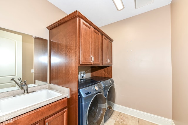 laundry room with light tile patterned floors, separate washer and dryer, cabinets, and sink