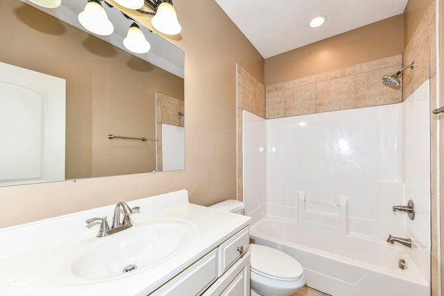 full bathroom with vanity, tiled shower / bath combo, and toilet