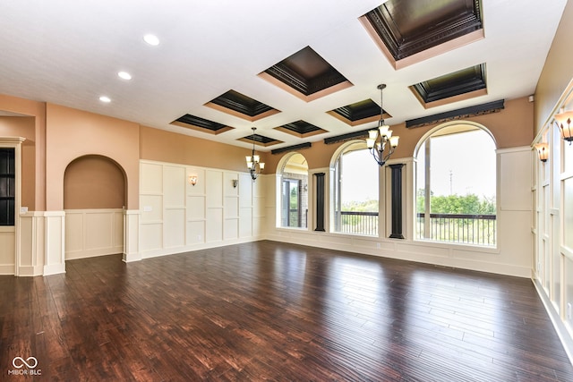 unfurnished room featuring coffered ceiling, dark hardwood / wood-style flooring, beam ceiling, and a healthy amount of sunlight