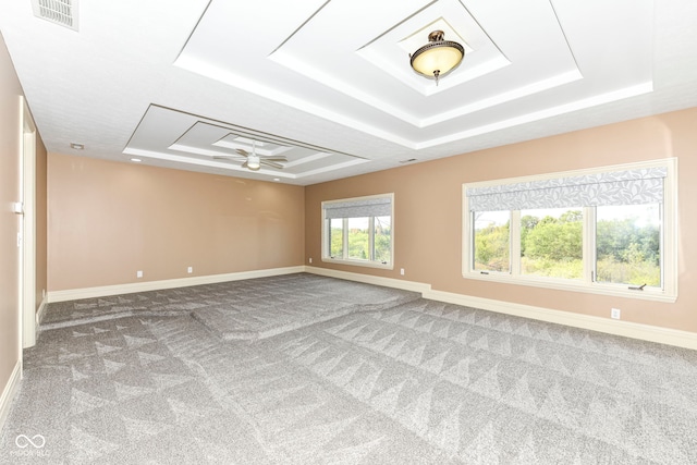 spare room featuring ceiling fan, a tray ceiling, and carpet floors