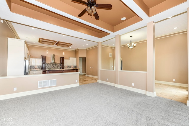 unfurnished living room with light colored carpet, ceiling fan with notable chandelier, and crown molding