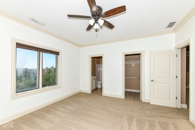 unfurnished bedroom with ornamental molding, light carpet, ensuite bath, and ceiling fan