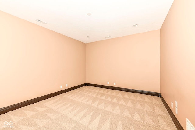 spare room featuring light colored carpet