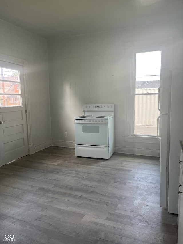 kitchen with white cabinets, light wood-type flooring, and white appliances